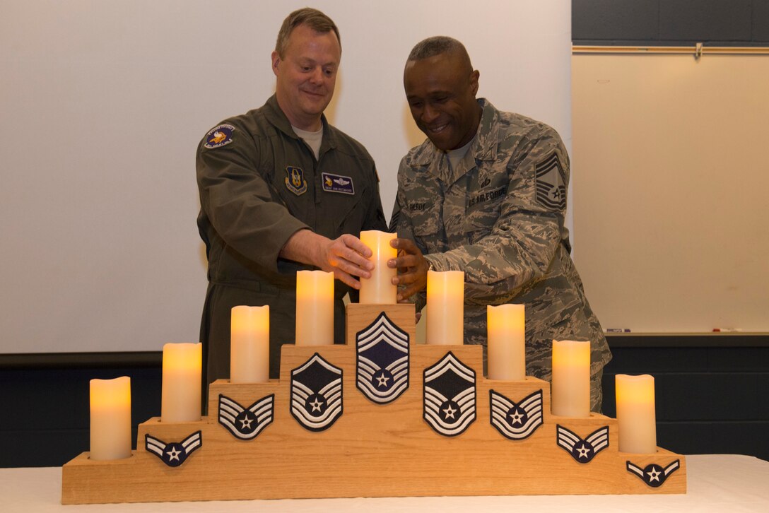 Chief Master Sgt. John Grutzmacher, 96th Airlift Squadron, and Chief Master Sgt. Victor Gilroy, 934th Force Support Squadron, light a candle in recognition of their level of rank during a promotion recognition ceremony at Minneapolis Air Reserve Station, Minn., May. 5, 2018. The ceremony is a time honored tradition commemorating the recognition of Airmen who have been promoted to a new tier of the enlisted ranks, signifying the levels of accomplishment each inductee has achieved in their Air Force career. (U.S. Air Force Photo by Tech. Sgt. Amber E. N. Jacobs)