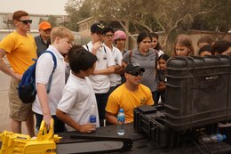 U.S. Army Staff Sgt. Richard Lee, center, assigned to the 74th Engineer Dive Detachment, showing the students from the American School of Kuwait a diver welding underwater with the remote operated vehicle (or ROV) from Seabotix ant Kuwait Naval Base, Kuwait, March 9, 2018.