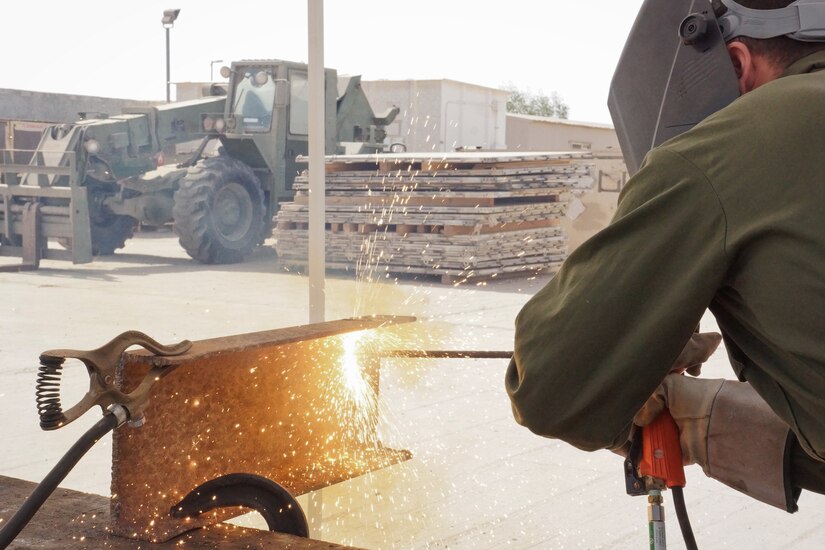 U.S. Army Spc. Pierce Castro cutting a project on surface at Kuwait Naval Base, Kuwait, March 27, 2018.