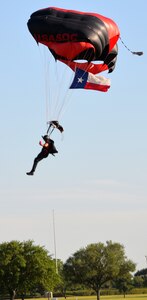 A member of the Black Daggers Parachute Demonstration Team, who are the U.S. Army Special Operations Command Parachute Team, carries the Texas state flag as he comes in for a landing May 6 during the Military Appreciation Weekend celebration at Joint Base San Antonio-Fort Sam Houston.