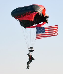 A member of the Black Daggers Parachute Demonstration Team, who are the U.S. Army Special Operations Command Parachute Team, carries the U.S. flag as he comes in for a landing May 6 during the Military Appreciation Weekend celebration at Joint Base San Antonio-Fort Sam Houston.