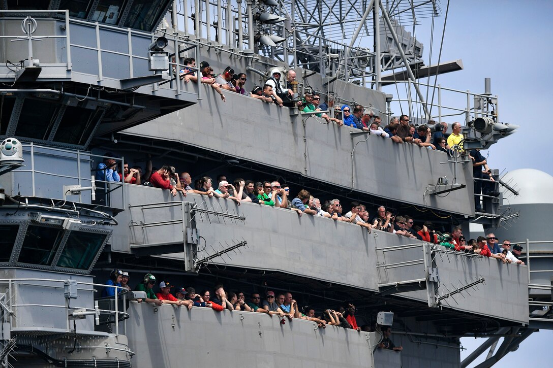 Sailors, Marines and guests watch an airpower demonstration.