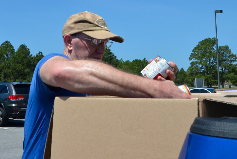TYNDALL AIR FORCE BASE, Fla. - Maj. Troy Lindig, 1st Air Force Communications Directorate, transfers cans from his rucksack to a box for transport to community food pantries and agencies in Panama City after he finished the second annual “5K Ruck March For Hunger” May 4 here.
Military and civilian members of 1st Air Force and the 601st Air Operations Center and their family members participated in the event to raise awareness about hunger along with food donations for community food pantries and agencies in the Panama City area.  Nearly 100 people donned 30+ lb. ruck sacks, back packs or donated food to support the food drive which raised 1,911 lbs. The drive began last year when a 1st Air Force Airman saw a statistic stating that numerous students in Bay County were going to school hungry.  (Air Force photo by Mary McHale)