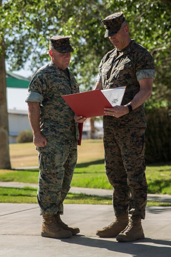 Maj. Gen. William F. Mullen III, commanding general, Marine Corps Air Ground Combat Center, presents Lt. Col. Robert L. Warfield II, director, Marine Corps Community Services, with a certification of retirement during Warfield’s retirement ceremony at the flag pole aboard the Marine Corps Air Ground Combat Center, Twentynine Palms, Calif., April 27, 2018. Warfield retired after 27 years of honorable service to the Marine Corps. (U.S Marine Corps photo by Lance Cpl. Margaret Gale)