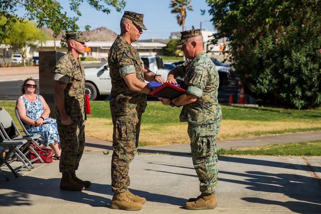 Maj. Gen. William F. Mullen III, commanding general, Marine Corps Air Ground Combat Center, presents Lt. Col. Robert L. Warfield II, director, Marine Corps Community Services, with an American flag during Warfield’s retirement ceremony at the flag pole aboard the Marine Corps Air Ground Combat Center, Twentynine Palms, Calif., April 27, 2018. Warfield retired after 27 years of honorable service to the Marine Corps. (U.S Marine Corps photo by Lance Cpl. Margaret Gale)