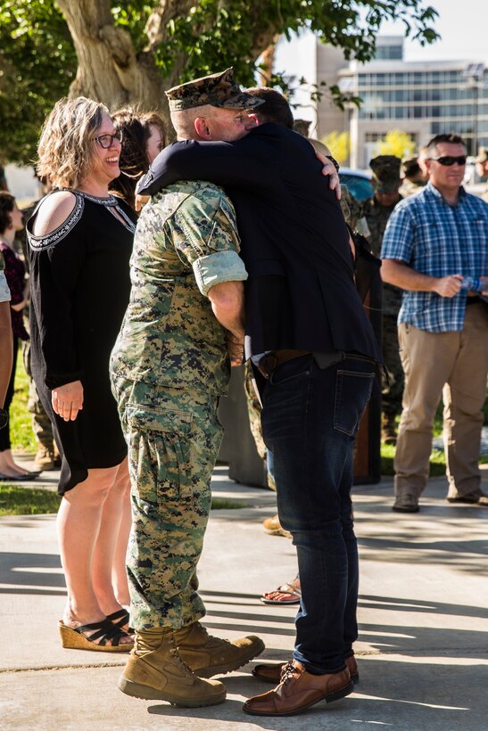 An attendee of the retirement ceremony for Lt. Col. Robert L. Warfield, director, Marine Corps Community Services, congratulates him after the ceremony at the flag pole aboard the Marine Corps Air Ground Combat Center, Twentynine Palms, Calif., April 27, 2018. Warfield retired after 27 years of honorable service to the Marine Corps. (U.S Marine Corps photo by Lance Cpl. Margaret Gale)