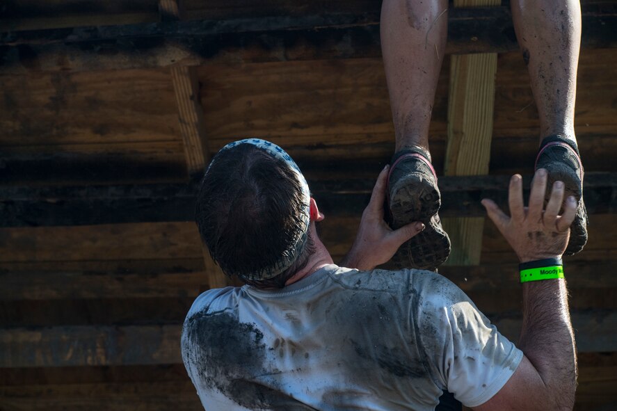 A Moody Mud Run participant helps a teammate, May 5, 2018, in Ray City, Ga. Participants trekked 4.6 miles through the mud, water and 29 obstacles that made up the course. This is the fifth year Moody has hosted the event and more than 800 patrons participated. (U.S. Air Force photo by Senior Airman Janiqua P. Robinson)