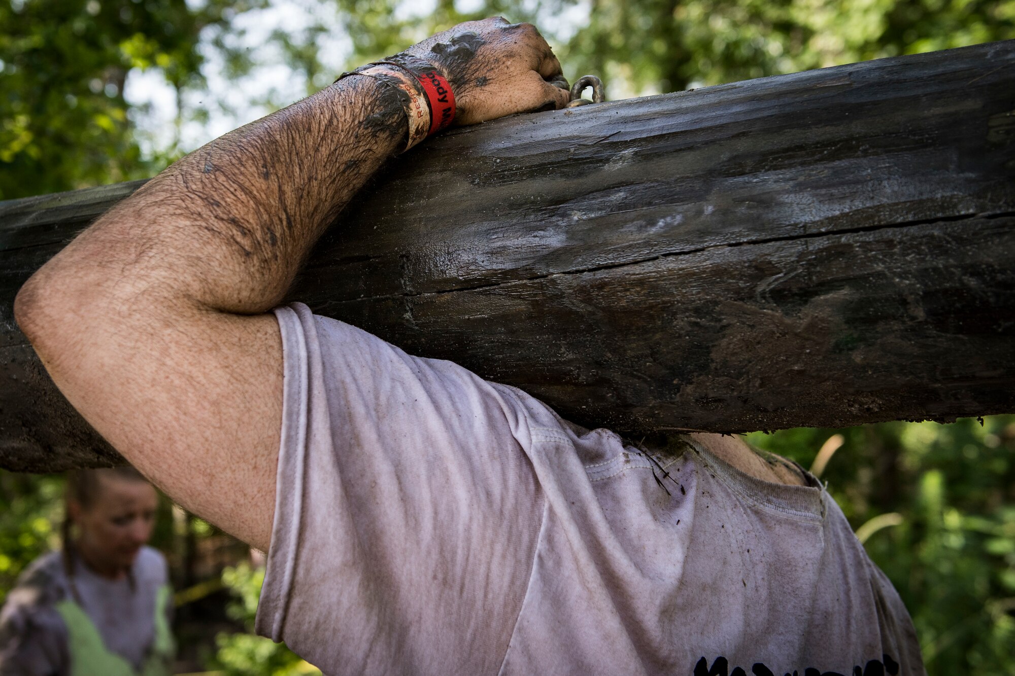 A Moody Mud Run participant carries a log, May 5, 2018, in Ray City, Ga. Participants trekked 4.6 miles through the mud, water and 29 obstacles that made up the course. This is the fifth year Moody has hosted the event and more than 800 patrons participated. (U.S. Air Force photo by Senior Airman Janiqua P. Robinson)