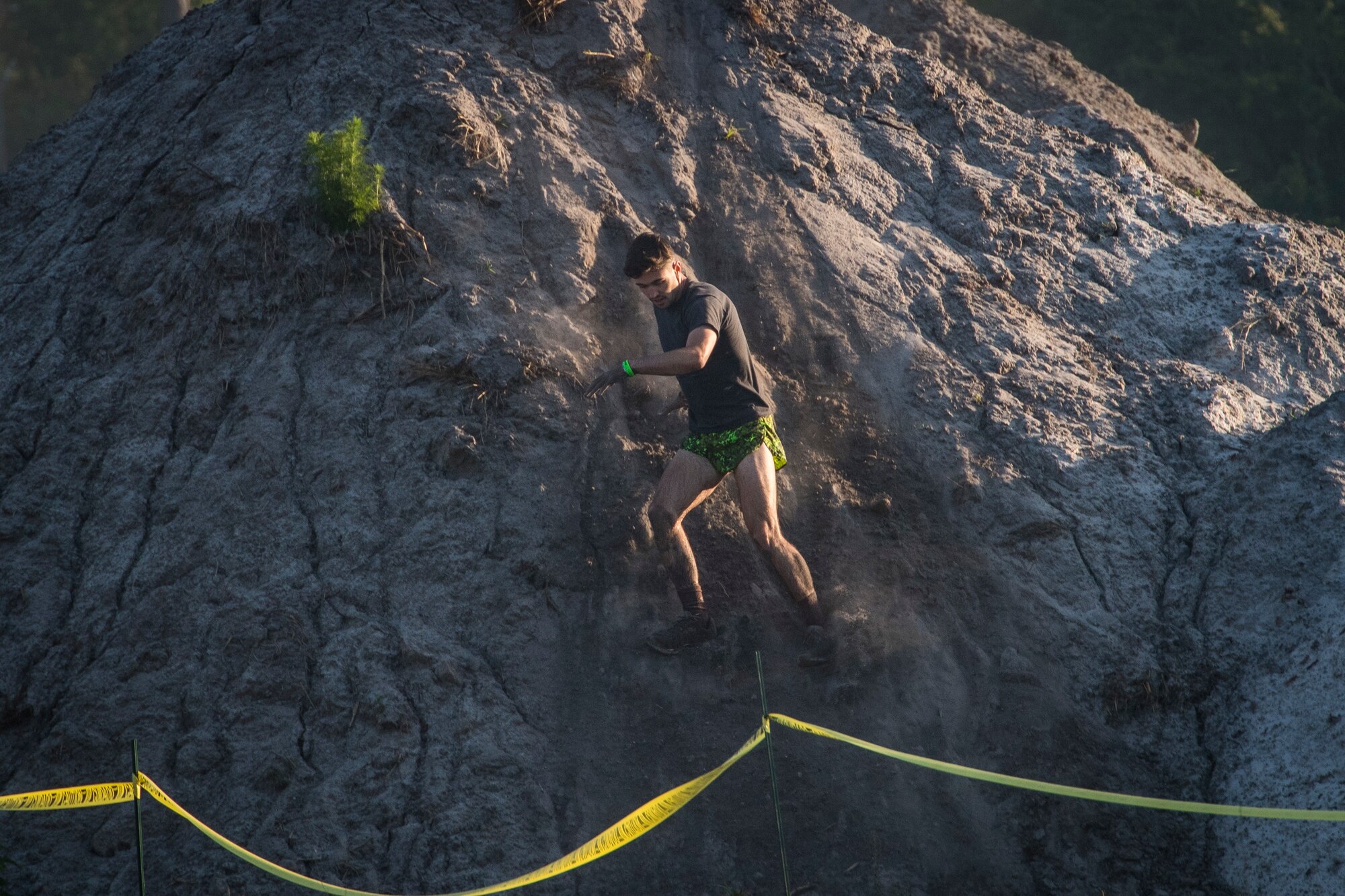 A Moody Mud Run participant slides down a hill, May 5, 2018, in Ray City, Ga. Participants trekked 4.6 miles through the mud, water and 29 obstacles that made up the course. This is the fifth year Moody has hosted the event and more than 800 patrons participated. (U.S. Air Force photo by Senior Airman Janiqua P. Robinson)
