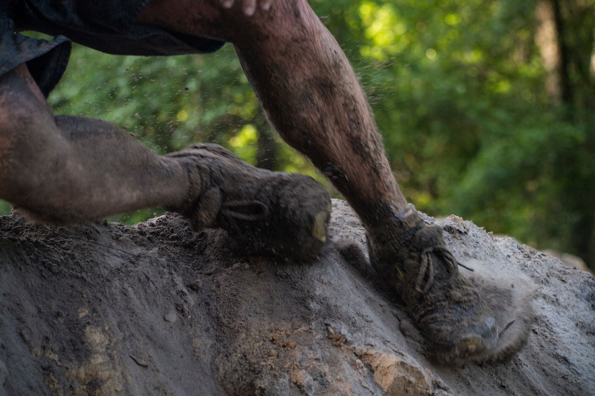 A Moody Mud Run participant slides down a hill, May 5, 2018, in Ray City, Ga. Participants trekked 4.6 miles through the mud, water and 29 obstacles that made up the course. This is the fifth year Moody has hosted the event and more than 800 patrons participated. (U.S. Air Force photo by Senior Airman Janiqua P. Robinson)