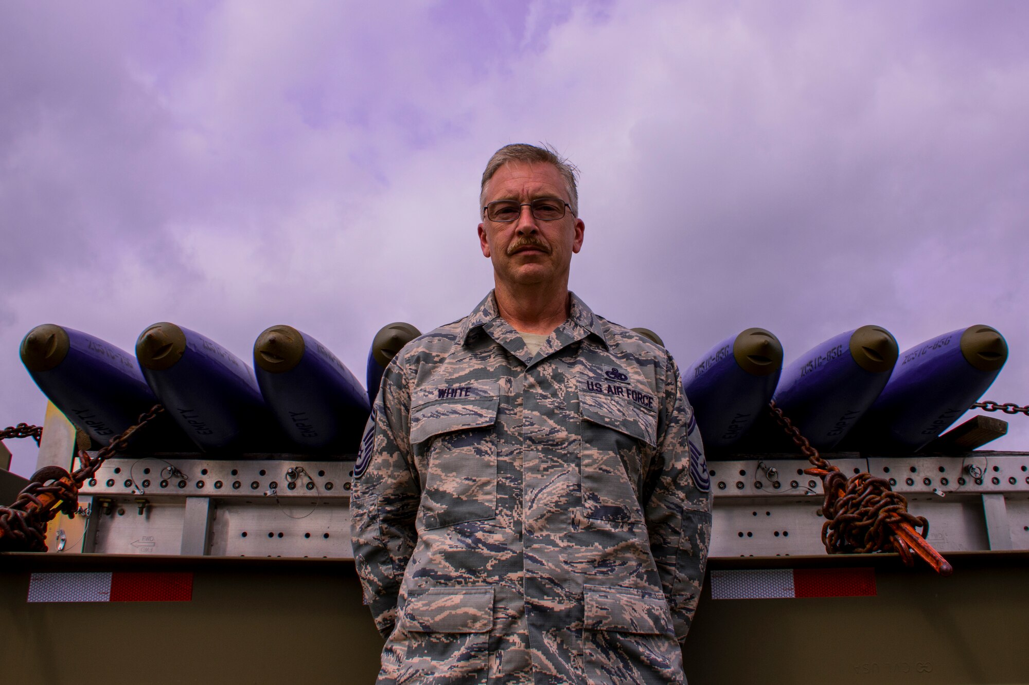 U.S. Air Force Senior Master Sgt. Kyle White, the 307th Maintenance Squadron munitions flight production section chief, stands in front of BDU-33 practice bombs at Barksdale Air Force Base, Louisiana, April 3, 2018.