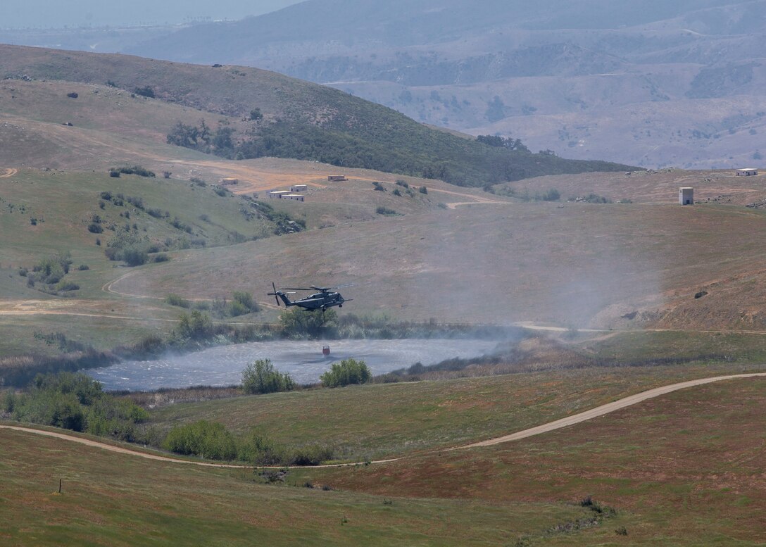 A CH-53E Super Stallion with Marine Heavy Helicopter Squadron (HMH) 462, Marine Aircraft Group 16, 3rd Marine Aircraft Wing, transports a firefighting bucket during the Corey Iverson Wildland Firefighting Exercise at Marine Corps Base Camp Pendleton, Calif., May 3. The exercise is an annual training event designed to increase emergency preparedness and cohesion between civilian and military firefighting agencies during California’s wildfire season. (U.S. Marine Corps photo by Lance Cpl. Clare J. McIntire/Released)
