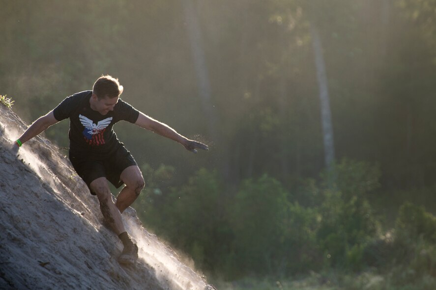 A Moody Mud Run participant slides down a dirt incline, May 5, 2018, in Ray City, Ga. Competitors trekked 4.6 miles through the mud, water and 29 obstacles that made up the course. This is the fifth year Moody has hosted the event and more than 800 patrons participated. (U.S. Air Force photo by Staff Sgt. Ryan Callaghan)