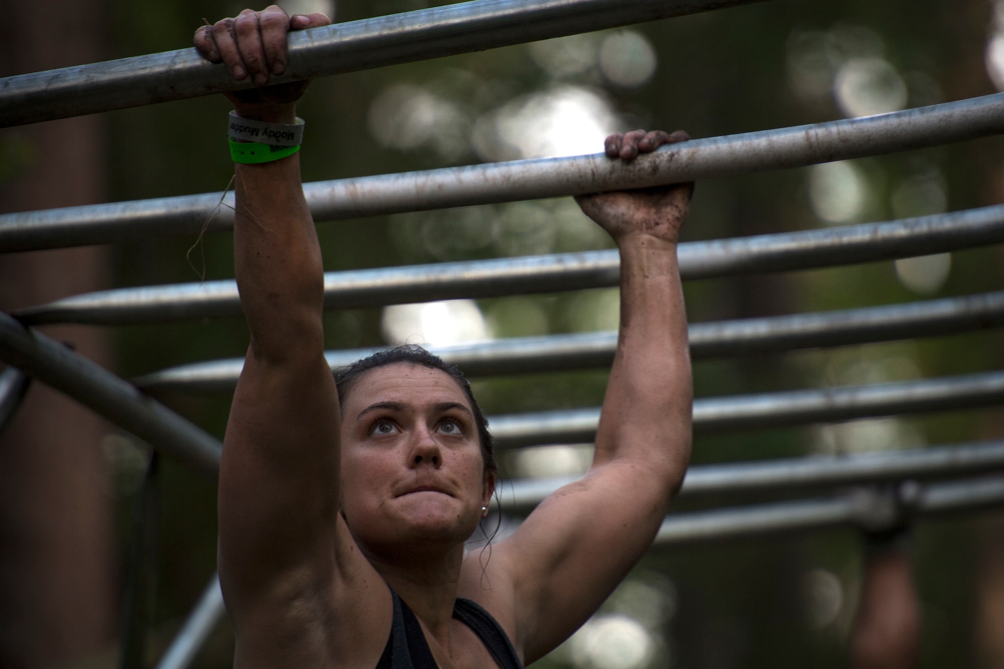 A Moody Mud Run participant crosses a monkey bars obstacle, May 5, 2018, in Ray City, Ga. Competitors trekked 4.6 miles through the mud, water and 29 obstacles that made up the course. This is the fifth year Moody has hosted the event and more than 800 patrons participated. (U.S. Air Force photo by Staff Sgt. Ryan Callaghan)