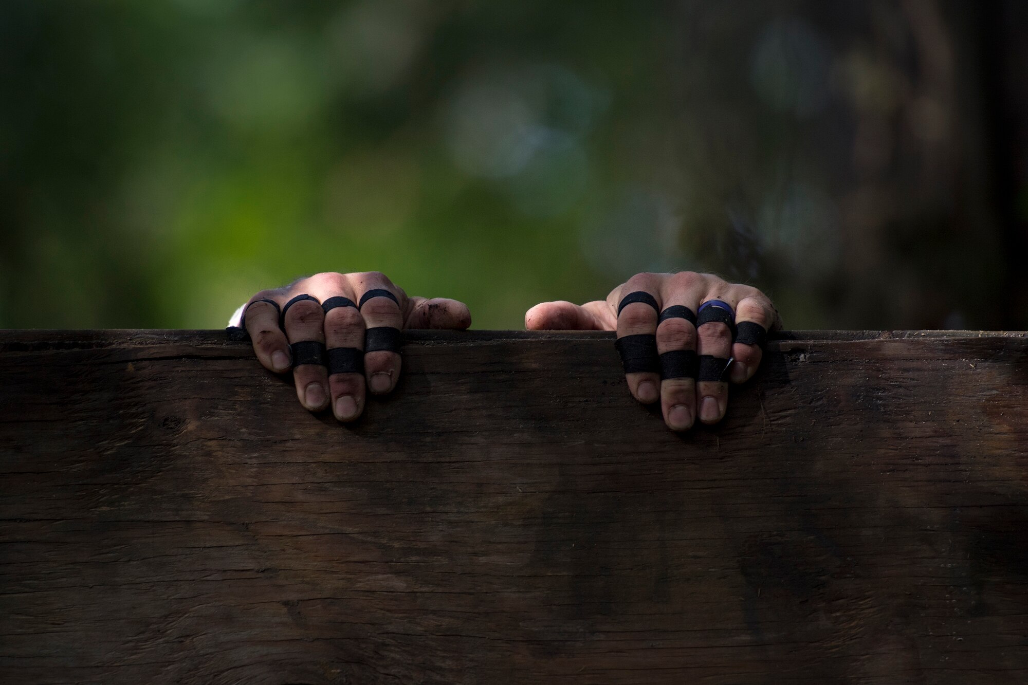 A Moody Mud Run participant hangs onto the top of a twelve-foot wall, May 5, 2018, in Ray City, Ga. Competitors trekked 4.6 miles through the mud, water and 29 obstacles that made up the course. This is the fifth year Moody has hosted the event and more than 800 patrons participated. (U.S. Air Force photo by Staff Sgt. Ryan Callaghan)