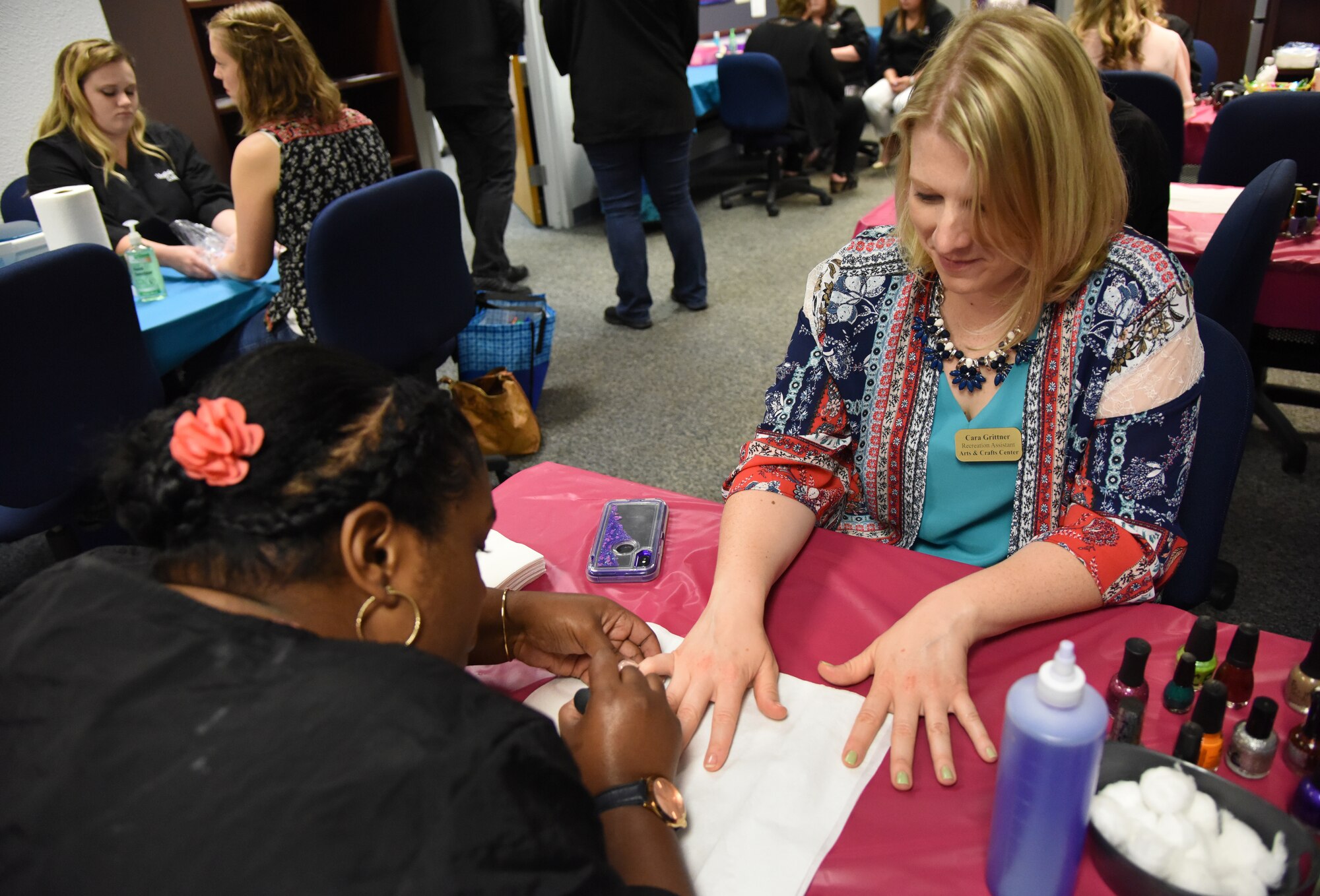 Tristan Mitchell, Virginia College cosmetology student, gives Cara Grittner, spouse of U.S. Air Force Tech. Sgt. Scott Grittner, Mathies NCO Academy instructor, a manicure during Pamper Me Day in the Sablich Center at Keesler Air Force Base, Mississippi, May 3, 2018. The 81st Force Support Squadron Airman & Family Readiness Center has hosted the event for the past 14 years, offering military spouses information and business booths, free manicures, makeup tips and giveaways. (U.S. Air Force photo by Kemberly Groue)