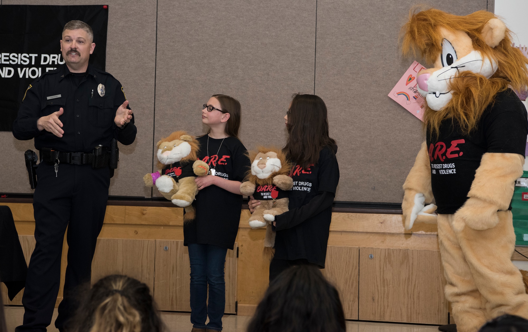 Michael J. Crerend, lead police officer with the 673d Security Forces Squadron and Drug Abuse Resistance Education officer, recognizes two students from the D.A.R.E. program for their achievements at Ursa Major Elementary School at Joint Base Elmendorf-Richardson, Alaska, May 2, 2018. D.A.R.E. is a program designed to provide students with the knowledge and tools they need to resist drugs, alcohol and other high-risk behaviors.