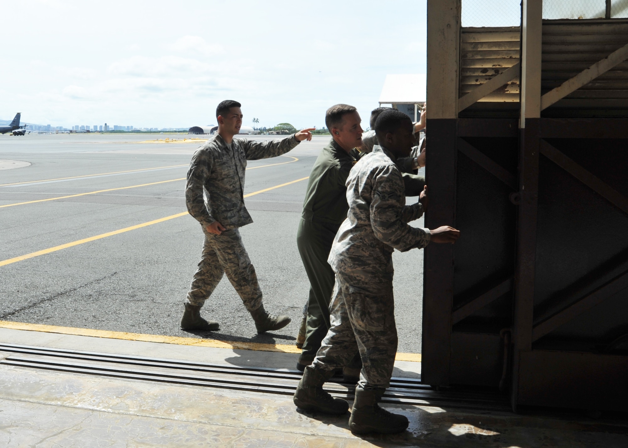 Col. Kevin Gordon, 15th Wing commander, opens one of the doors to Hangar 35 with the help of Airmen from the 15th Maintenance Group, Joint Base Pearl Harbor-Hickam, Hawaii, May 4, 2018.
