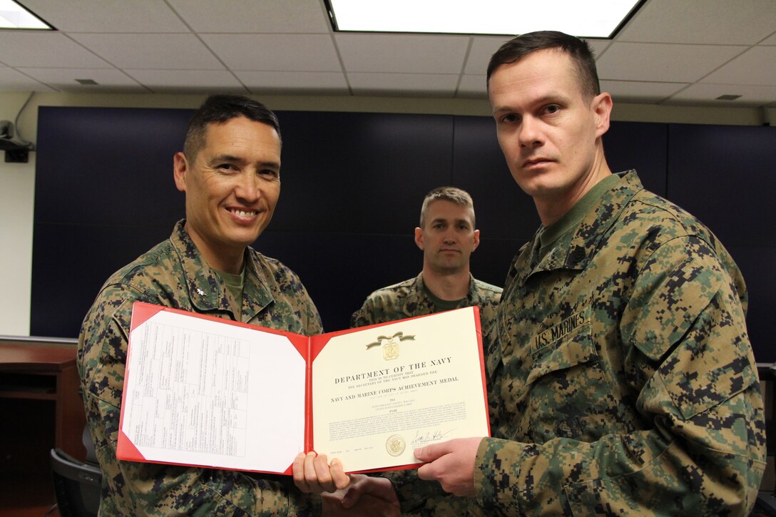 U.S. MARINE CORPS BASE, CAMP MUJUK – Staff Sgt. Jason Wallace (right), a U.S. Marine Corps Forces Korea individual augment from the San Diego Marine Corps Recruiting District Provost Marshall Office, receives a Navy and Marine Corps Achievement Medal presented by Lt. Col. Sam L. Roy, MARFORK G-3 deputy current operations officer here, May 3. Wallace received his award for going above and beyond while fulfilling his responsibilities with the unit.  (U.S. Marine Corps photo by Sgt. Nathaniel Hanscom/Released)