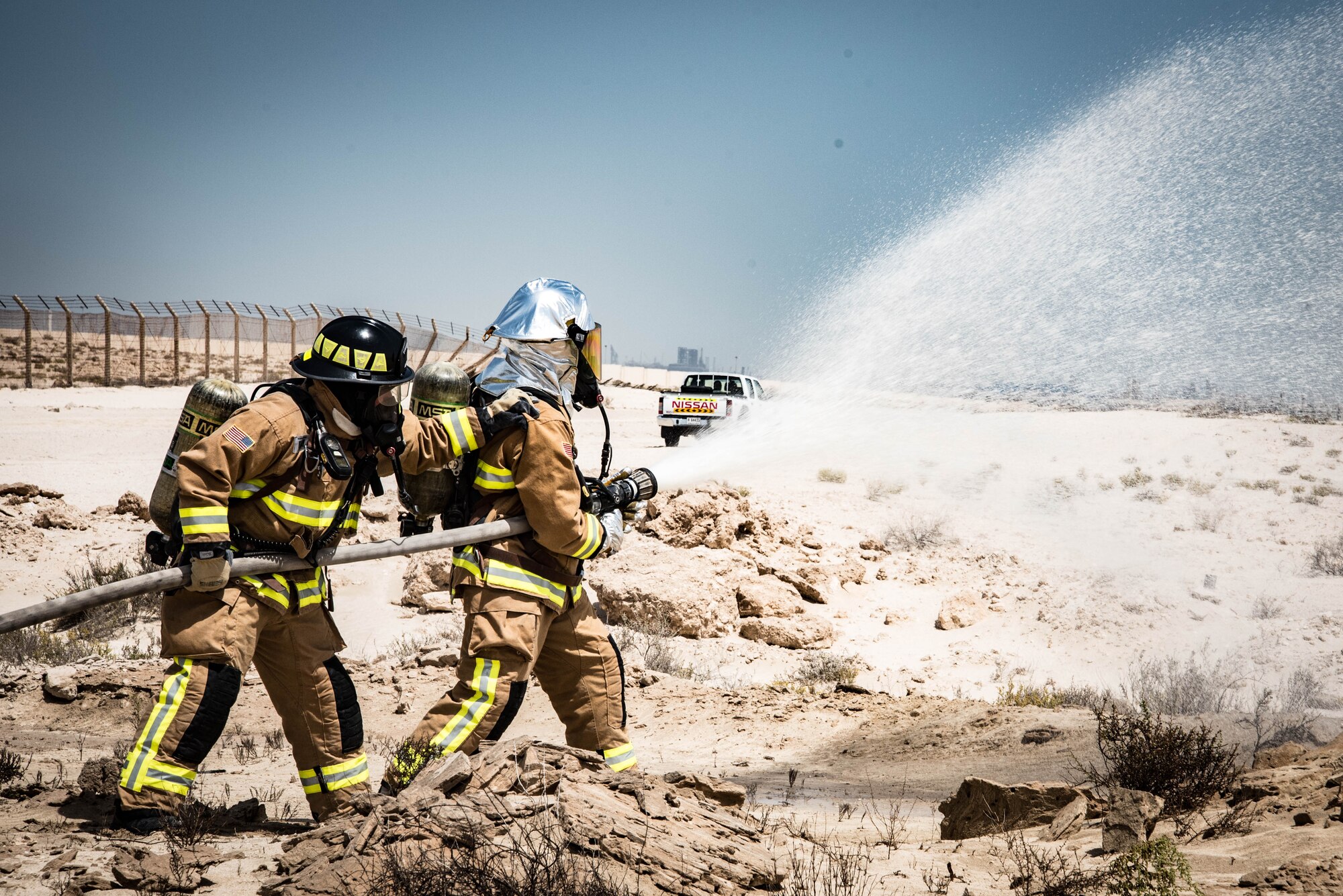 Firefighters from the 380 Exepidtionary Civil Engineer Squadron spray a simulated fire for a joint agency exercise here, May 2. (U.S. Air National Guard photo by Staff Sgt. Erica Rodriguez)