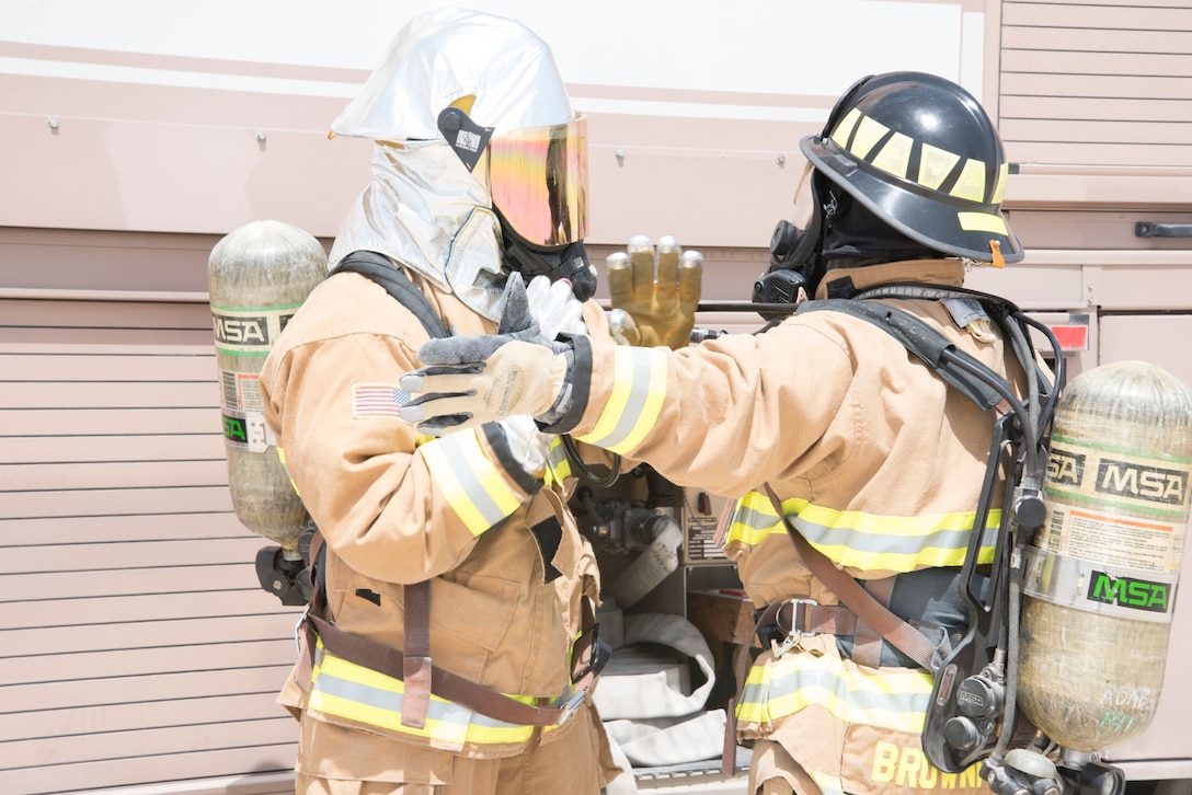 Two U.S. Air Force fire fighters from the 380th Expeditionary Civil Engineer Squadron check their equipment during a joing agency exercise here, May 2. (U.S. Air National Guard photo by Staff Sgt. Erica Rodriguez)