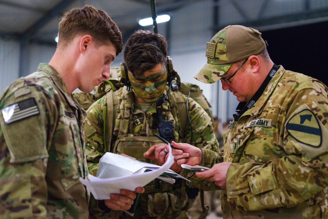 Soldiers discusses flight operations for a night assault mission.