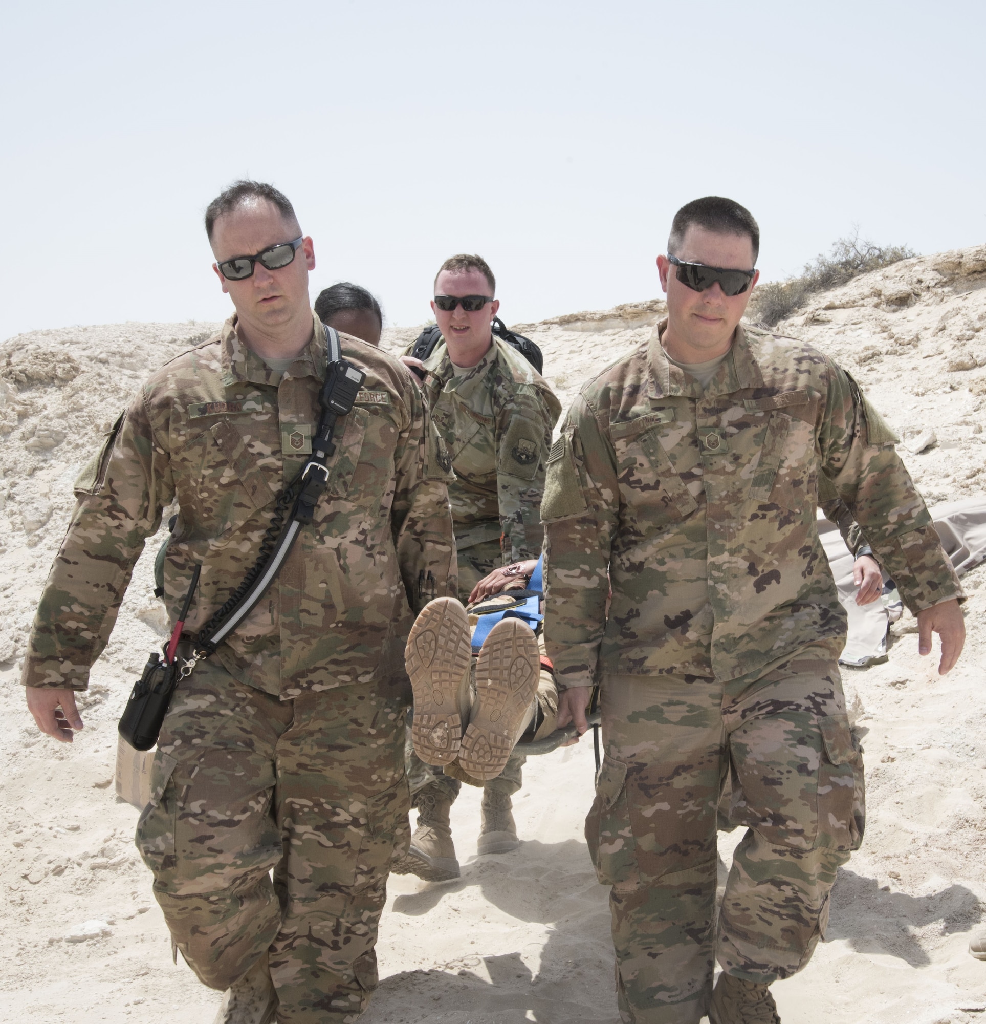 U.S. Air Force members from the 380th Expeditionary Medical group lift a litter carrying a role-playing injured pilot during a joint agency exercise here, May 2. (U.S. Air National Guard photo by Staff Sgt. Erica Rodriguez)