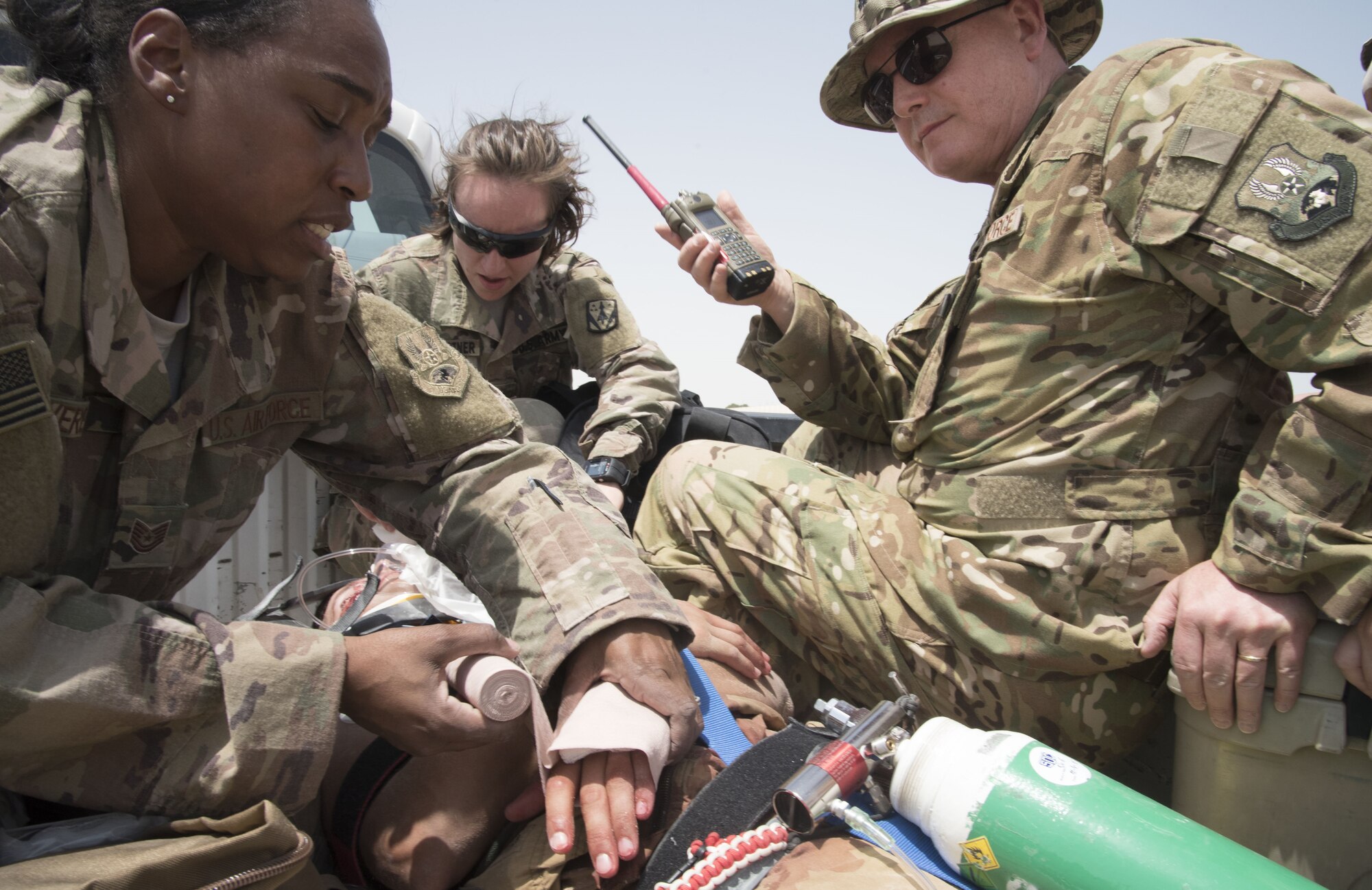 U.S. Air Force members from the 380th Expeditionary Medical Group simulates a dispatch call to the crisis action team while treating a role-playing injuried pilot during a joint agency exercise here, May 2. (U.S. Air National Guard photo by Staff Sgt. Erica Rodriguez)