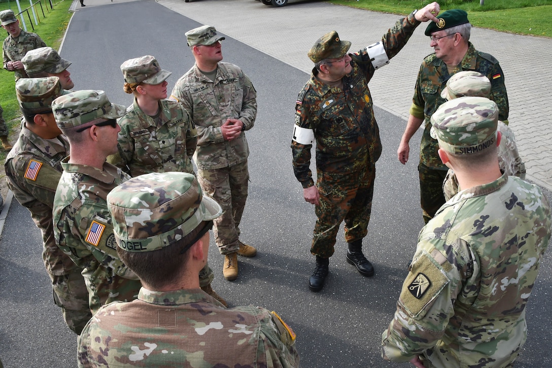 A German soldier explains unit insignias to U.S. soldiers.