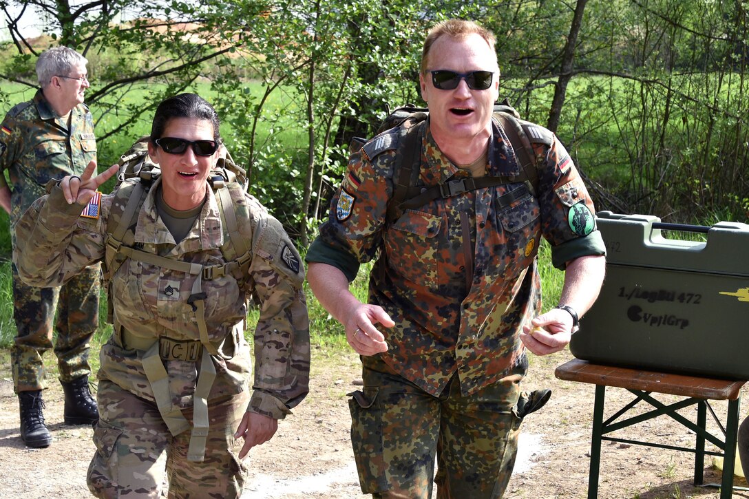 A German and U.S. soldier participate in a ruck march.