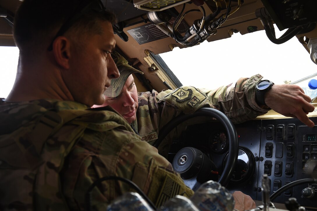 Staff Sgt. Nathan Wolf, 407th Expeditionary Security Forces Squadron craftsman, explains the controls of a Mine Resistant Ambush Protected All-Terrain Vehicle, or M-ATV, to Col. John Gonzales, 407th Air Expeditionary Group commander.