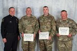 U.S. Army Sgt. 1st Class Neal Stratman, 2nd Battalion, 196th Regional Training Institute, South Dakota Army National Guard, right, Capt. Carl Stearns, 152nd Combat Sustainment Support Battalion, South Dakota Army National Guard, middle right, and Sgt. 1st Class Matt Tjaden, 1742nd Transportation Company, South Dakota Army National Guard, receive the Outstanding Citizen Award from Police Chief Matt Burns, Sioux Falls Police Department, in Sioux Falls, S.D., April 26, 2018. The award was presented for their actions and initiative at the scene of a car collision in Sioux Falls, S.D., March 7, 2018.