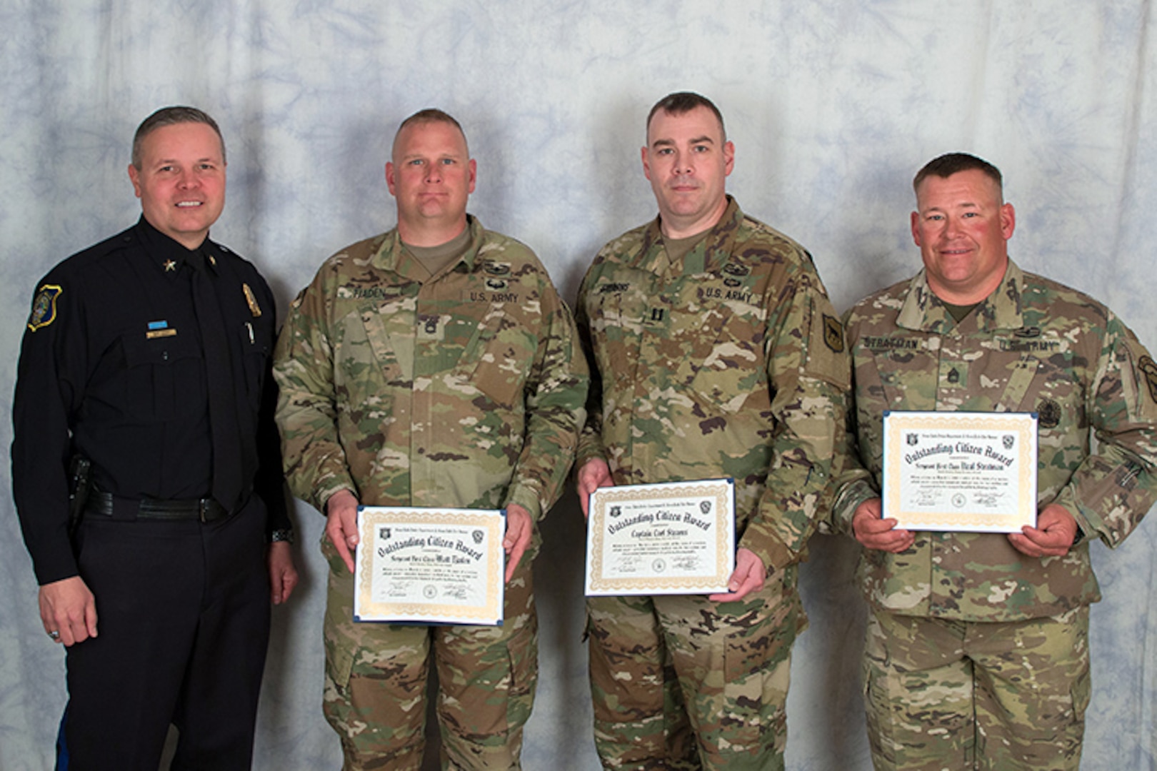 U.S. Army Sgt. 1st Class Neal Stratman, 2nd Battalion, 196th Regional Training Institute, South Dakota Army National Guard, right, Capt. Carl Stearns, 152nd Combat Sustainment Support Battalion, South Dakota Army National Guard, middle right, and Sgt. 1st Class Matt Tjaden, 1742nd Transportation Company, South Dakota Army National Guard, receive the Outstanding Citizen Award from Police Chief Matt Burns, Sioux Falls Police Department, in Sioux Falls, S.D., April 26, 2018. The award was presented for their actions and initiative at the scene of a car collision in Sioux Falls, S.D., March 7, 2018.