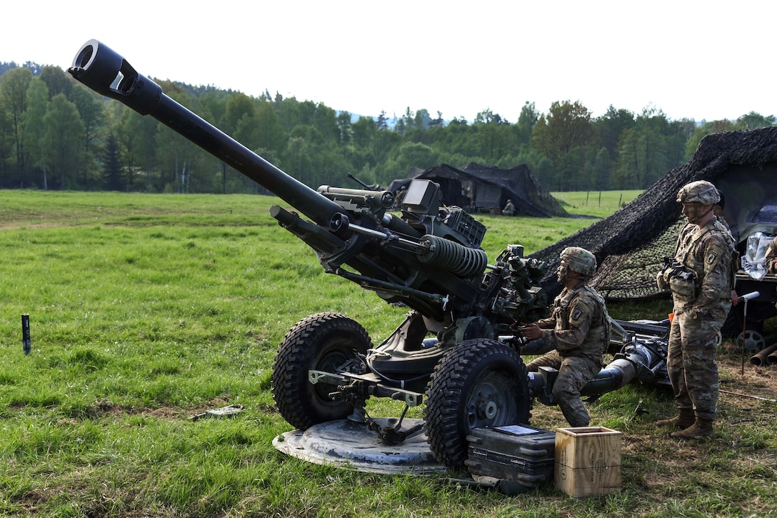 Soldiers prepare to fire an M119 105mm howitzer during a live-fire exercise.