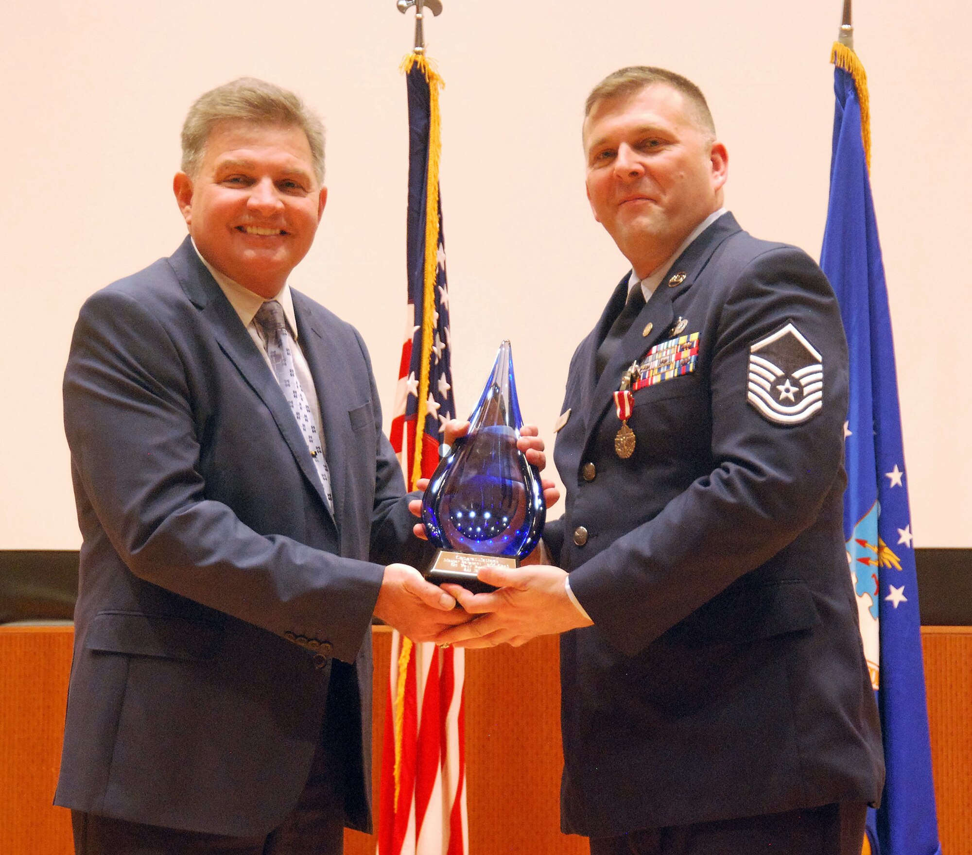655th Intelligence, Surveillance and Reconnaissance Chief Master Sgt.David L. Wright (left) presents Unit Training Manager and Unit Deployment Manager Master Sgt. Todd Cook a gift from the unit at his retirement ceremony, here, April 21, 2018. Cook retired after 23 years of service. (U.S. Air Force photo/2nd Lt. Weston Woodward)
