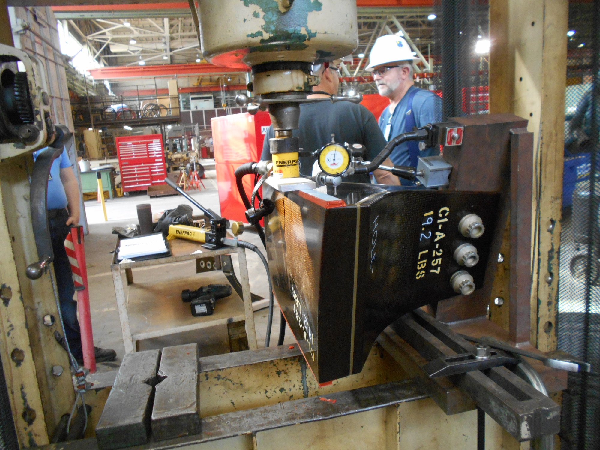 A compressor blade spacer is installed in a hydraulic press machine for load simulations in the Arnold Air Force Base Model and Machine Shop. Machinists recently aided Propulsion Wind Tunnel 16T personnel in the completion of compressor blade spacer testing.