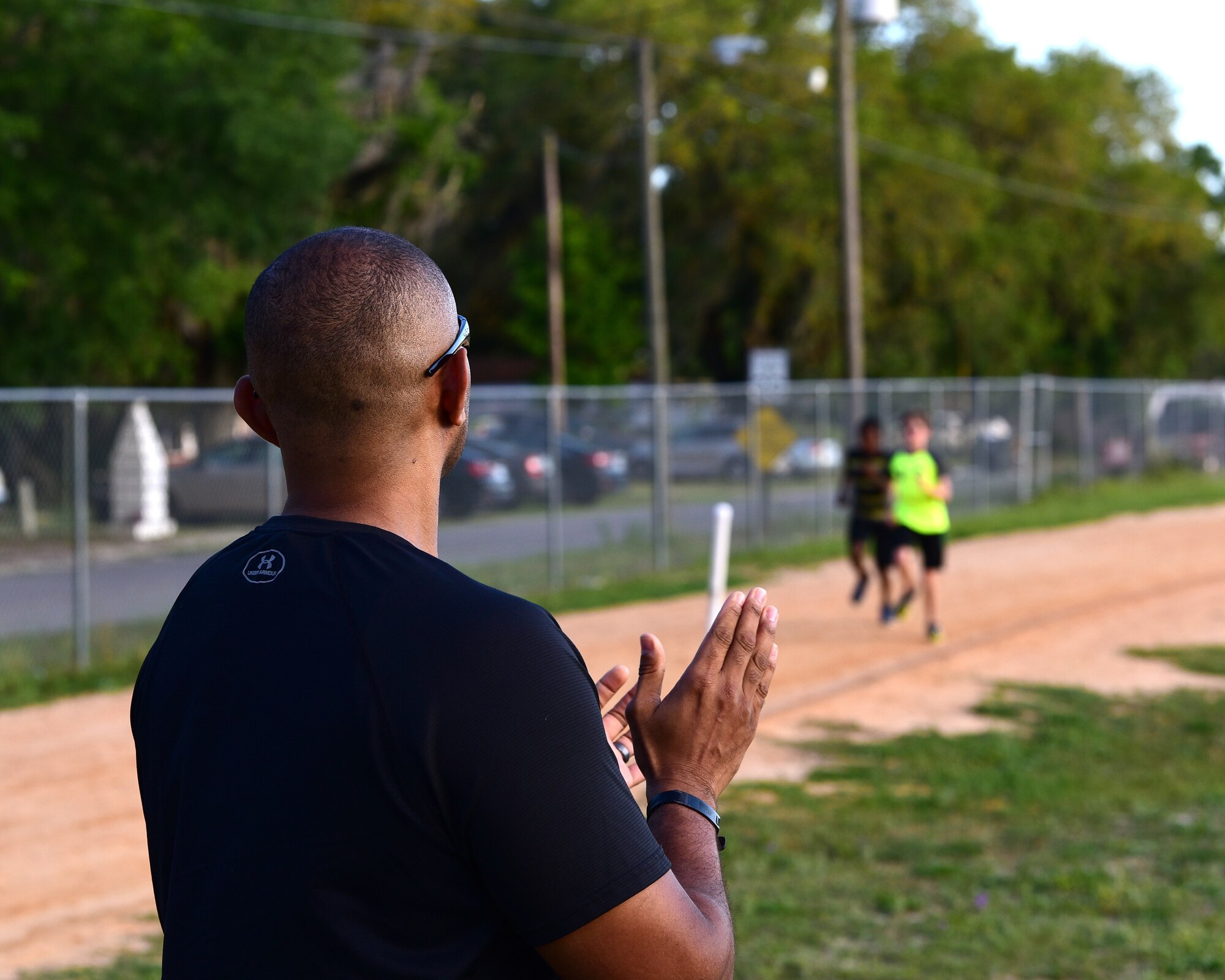 U.S. Air Force Senior Master Sgt. Antonio Mack, 325th Fighter Wing Air Forces Northern/Tyndall Command Center and 325th Fighter Wing Staff Agency superintendent, encourages his athletes to finish a lap around the track at Rutherford High School in Panama City, Fla., April 24, 2018. Mack said he believes sports are a positive influence for children and teach them both teamwork and resiliency in the face of hardship. (U.S. Air Force photo by Senior Airman Cody R. Miller/Released)