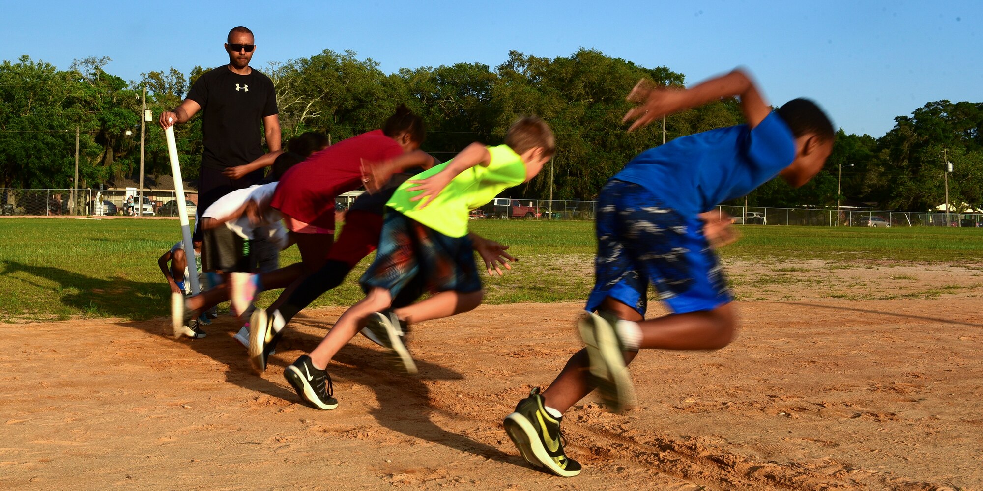 U.S. Air Force Senior Master Sgt. Antonio Mack, 325th Fighter Wing Air Forces Northern/Tyndall Command Center and 325th Fighter Wing Staff Agency superintendent, watches his athletes take off for a sprint exercise at Rutherford High School in Panama City, Fla., April 24, 2018. Mack coaches children in the local community, including his son, on both distance running and sprinting. (U.S. Air Force photo by Senior Airman Cody R. Miller/Released)