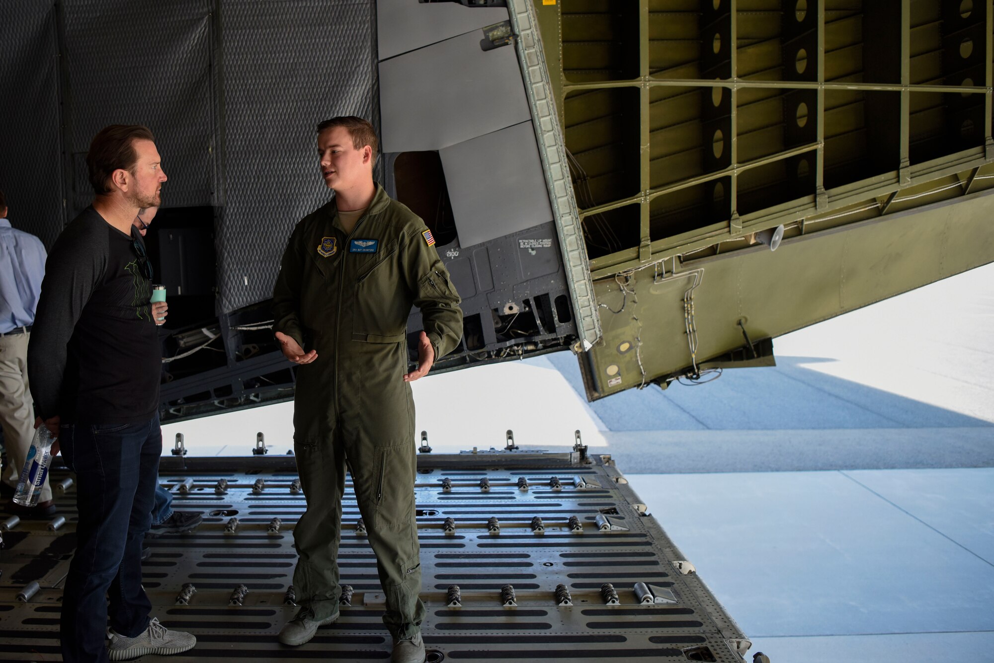 Senior Airman Guy Crawford, 9th Airlift Squadron C-5M Super Galaxy loadmaster, talks to Kurt Busch, driver of the No. 41 Stewart-Haas Racing Ford Fusion car, aboard a C-5M May 3, 2018, at Dover Air Force Base, Del. Along with a tour of the aircraft, Busch also had the chance to fly a C-5 simulator. (U.S. Air Force photo by Airman 1st Class Zoe M. Wockenfuss)