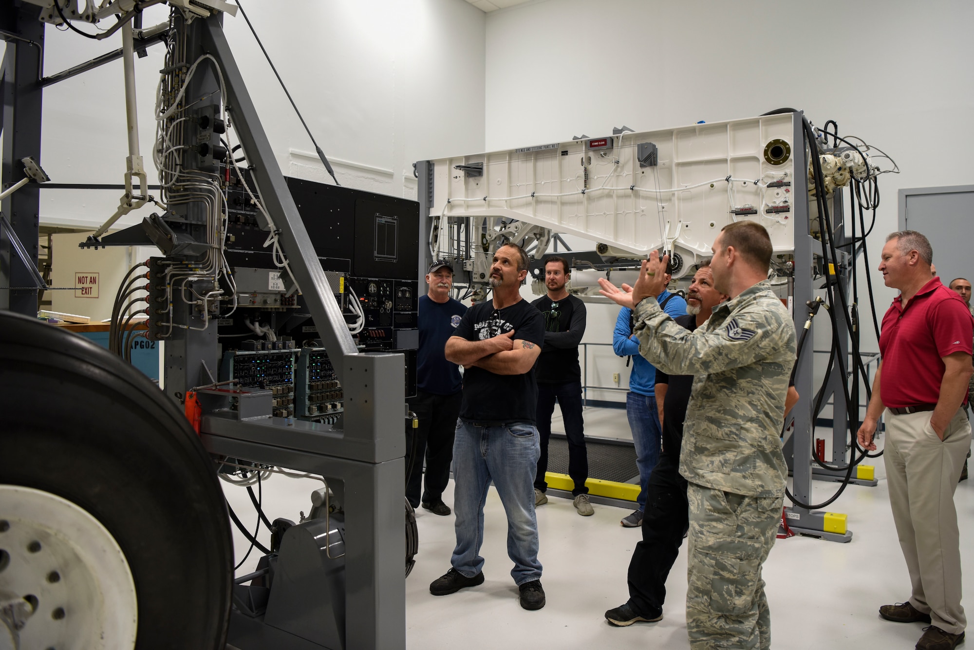 Staff Sgt. Alex Taylor, 373rd Training Squadron Detachment 3 C-5M Mission Ready Airmen instructor, explains the landing gear on a C-5M Super Galaxy to NASCAR members during a tour May 3, 2018, at Dover Air Base, Del. The group also toured a C-5 earlier in the day. (U.S. Air Force photo by Airman 1st Class Zoe M. Wockenfuss)