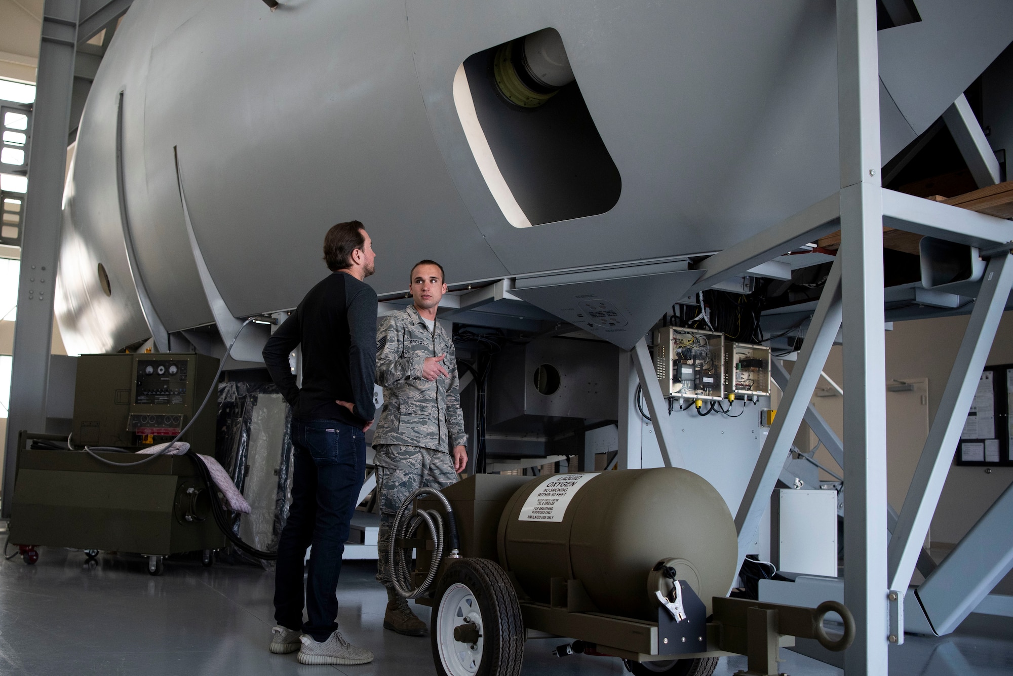 Tech. Sgt. Ross Krotzer, 373rd Training Squadron Detachment 3 C-17 Environmental and Electrical instructor, talks to Kurt Busch, driver of the No. 41 Stewart-Haas Racing Ford Fusion car, during a tour of the 373rd TS Det. 3 May 3, 2018, at Dover Air Force Base, Del. Busch and Krotzer discussed the similarities and differences between racing and flying. (U.S. Air Force photo by Airman 1st Class Zoe M. Wockenfuss)