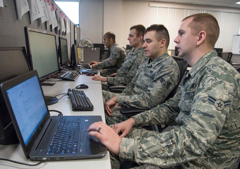 (From left to right) Senior Airman Nigel Krueger, Airman 1st Class Lucas Huesmann, Senior Airman Daniel Gearhart, Airman 1st Class Joshua Perry, 375th Communications Support Squadron Air Mobility Command software developers, work on several software applications April 17, 2018, at Scott Air Force Base, Illinois. The 375th CSPTS supports the 375th Air Mobility Wing in its global reach mission by providing, command, control, communications and computer support to the Department of Defense, United States Transportation Command, AMC, 18th Air Force and others worldwide. (U.S. Air Force photo by Senior Airman Melissa Estevez)