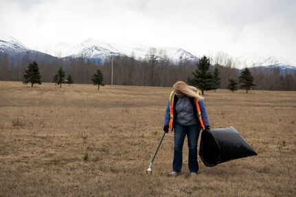 Pam Brunean, an Aurora Military Housing inspector, picks up trash and debris as she walks in a neighborhood at Joint Base Elmendorf-Richardson, Alaska, May 3, 2018. JBER participated in Operation Clean Sweep in support of the Anchorage Chamber of Commerce's 50th Annual Citywide Cleanup campaign.