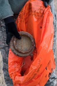 Tech. Sgt. Chad Moses, 773d Civil Engineer Squadron alarm shop noncommissioned officer in charge, picks up a piece of metal debris as he walks down a road at Joint Base Elmendorf-Richardson, Alaska, May 4, 2018. JBER participated in Operation Clean Sweep in support of the Anchorage Chamber of Commerce's 50th Annual Citywide Cleanup campaign.