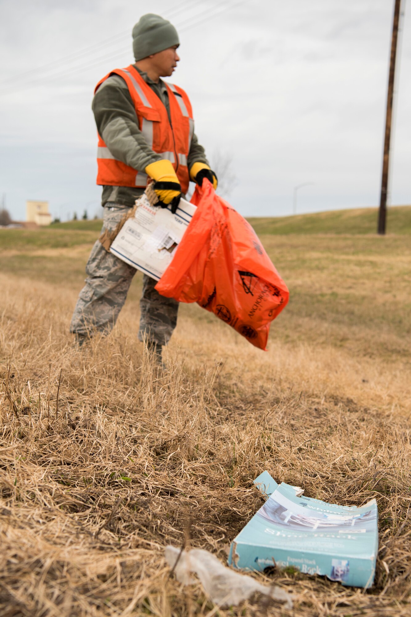 Air Force Staff Sgt. Marlon Lotoc, 773d Civil Engineer Squadron electrical craftsman picks up trash and debris as he walks down a road at Joint Base Elmendorf-Richardson, Alaska, May 4, 2018. JBER participated in Operation Clean Sweep in support of the Anchorage Chamber of Commerce's 50th Annual Citywide Cleanup campaign.