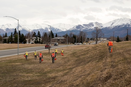 Airmen with the 773d Civil Engineer Squadron scan for trash and debris as they walk down a road at Joint Base Elmendorf-Richardson, Alaska, May 4, 2018. JBER participated in Operation Clean Sweep in support of the Anchorage Chamber of Commerce's 50th Annual Citywide Cleanup campaign.