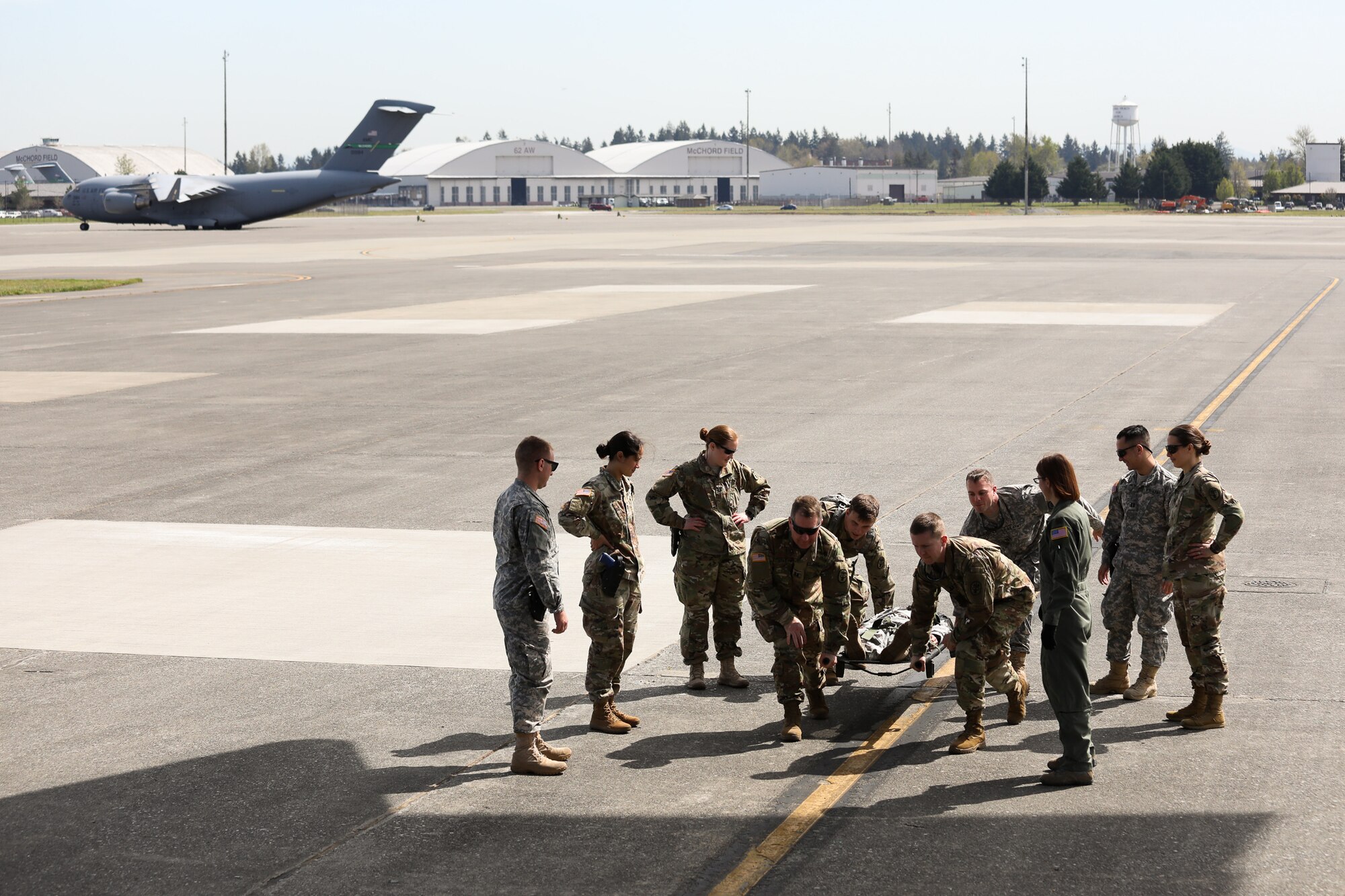 Graduating medical professionals from Madigan Army Medical Center carry a simulated patient onto a C-17 Globe - Master III on 25 April, 2018, at McChord Field, Wash. The 446th Aeromedical Evacuation Squadron took part in this three day capstone training event with the U.S. Army to show how patients are cared for once transported out of a combat environment.