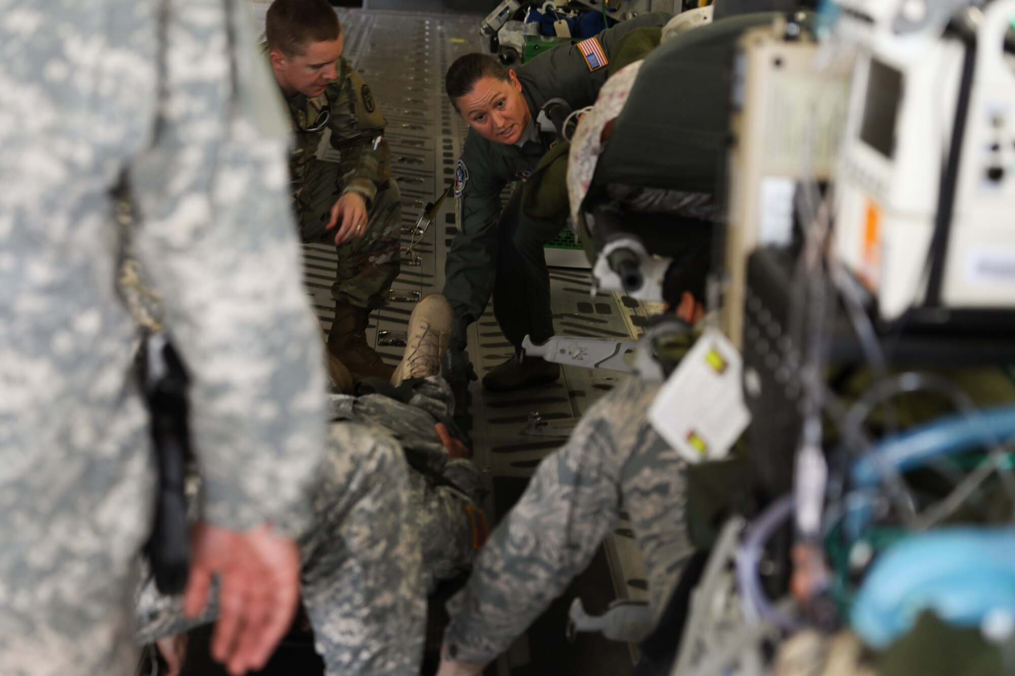 Graduating medical professionals from Madigan Army Medical Center carry a simulated patient onto a C-17 Globe - Master III on 25 April, 2018, at McChord Field, Wash. The 446th Aeromedical Evacuation Squadron took part in this three day capstone training event with the U.S. Army to show how patients are cared for once transported out of a combat environment.