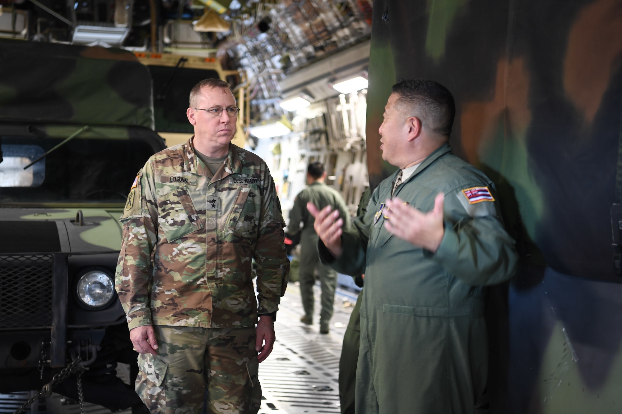 U.S. Air Force Master Sgt. Garrick Hiramoto, a loadmaster with the Hawaii Air National Guard’s 204th Airlift Squadron, provides U.S. Army Maj. Gen. Arthur Logan, adjutant general for the Hawaii National Guard, an update during a joint airlift inspection training event May 5, 2018, at Joint Base Pearl Harbor-Hickam, Hawaii. The event, which included the U.S. Army Reserve's 3302nd Mobilization Support Battalion from Fort Shafter, Hawaii, and the 204th AS and U.S. Air Force Reserve’s 48th Aerial Port Squadron at JBPH-H, Hawaii, was a collaborative effort to build working relationships between services, improve proficiencies, and teach participants how to inspect vehicles and cargo for airlift operations. (U.S. Air Force photo by Master Sgt. Theanne Herrmann)