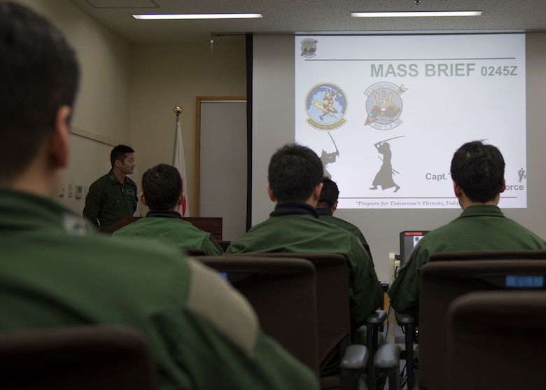 Japan Air Self-Defense Force pilots with the 3rd Air Wing attend a mass briefing on dissimilar air combat tactics at Misawa Air Base, Japan, April 12, 2018. The DACT program provides a realistic application of fighter tactics and serves to develop a high level of tactical skill for all combat aircrews. (U.S. Air Force photo by Airman 1st Class Collette Brooks).
